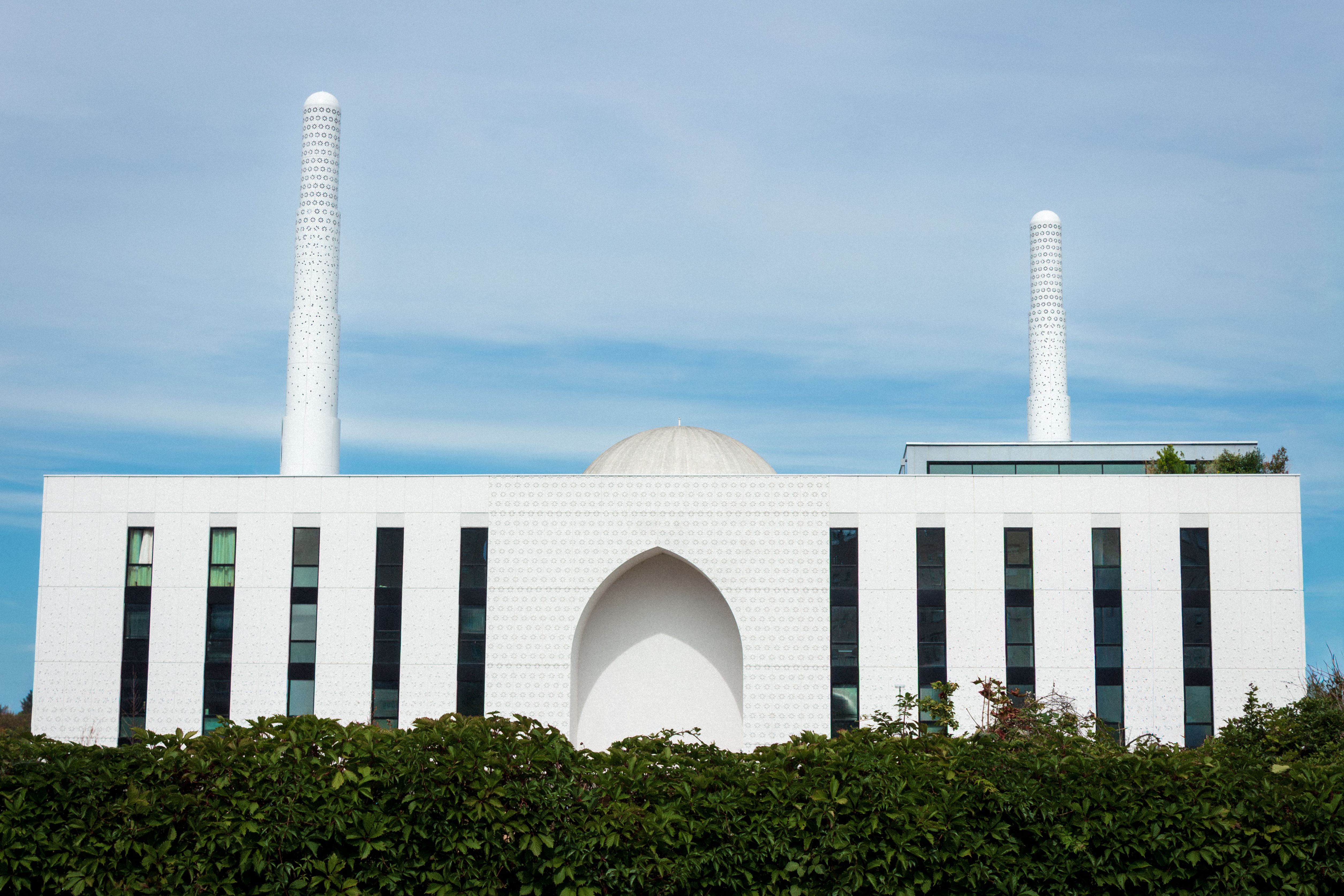 White mosque with minarets and geometric design in Paris, showcasing modern Islamic architecture.