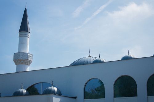 Free A modern mosque's minaret and domes against a blue sky in Genk, Belgium. Stock Photo