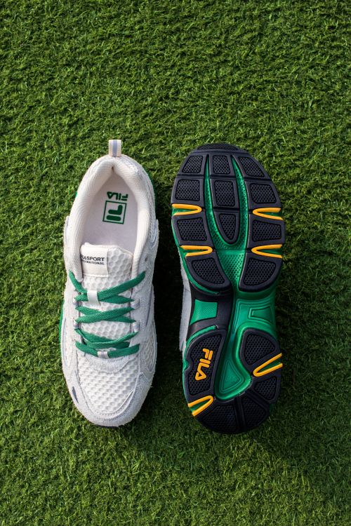 Free Pair of white and green sports shoes displayed on artificial grass, Vietnam. Stock Photo