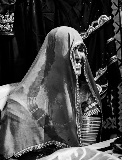 Free Black and white portrait of a smiling woman wearing a traditional veil and attire. Stock Photo