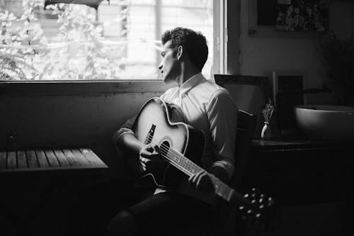 Man Playing Guitar In Grayscale Photography