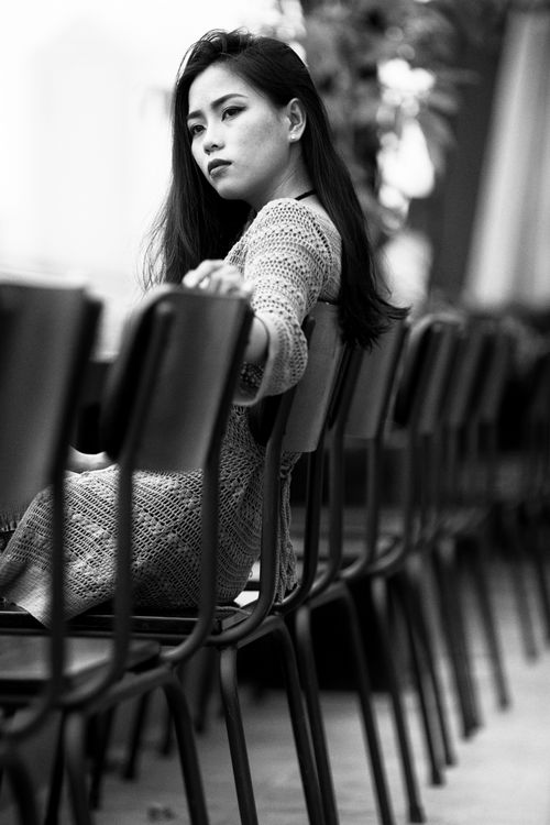 Free Black and white portrait of a woman sitting in a thoughtful pose indoors. Stock Photo