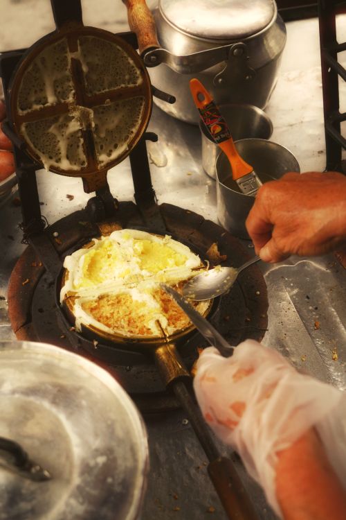 Free Hands preparing crispy waffles in an iron press at a street market. Stock Photo