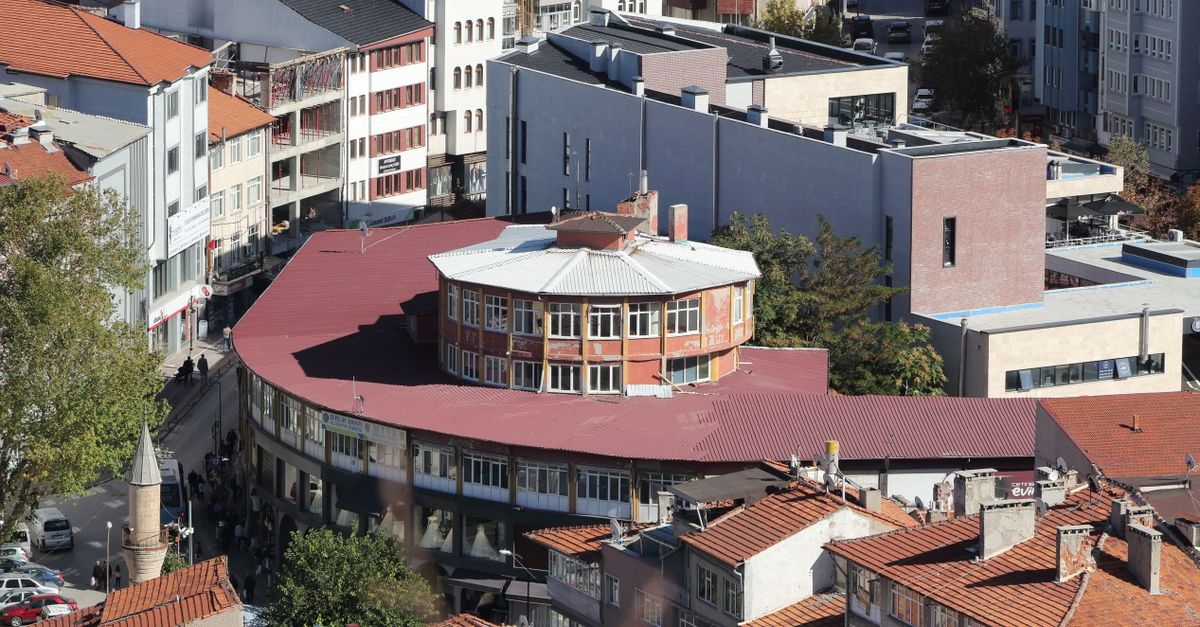Aerial view of a cityscape with distinctive red roofs and modern buildings.