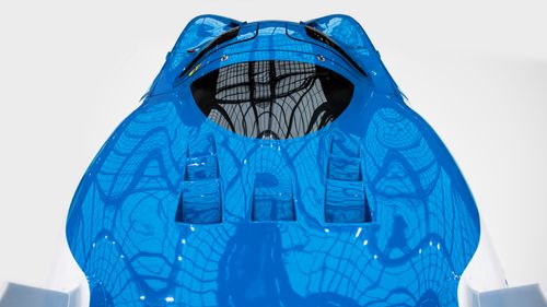 Free Close-up of a blue racing car with a reflective surface and dynamic design. Stock Photo