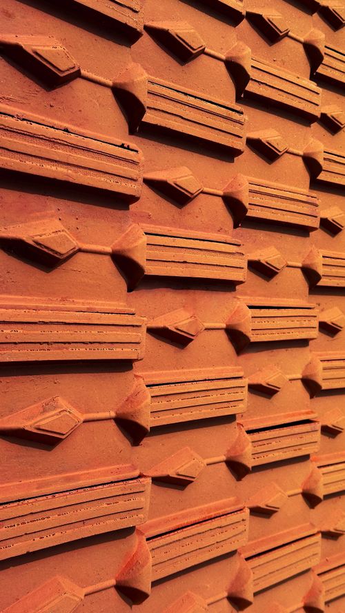 Free Detailed view of a red brick wall with a unique geometric pattern, creating a textured abstract design. Stock Photo