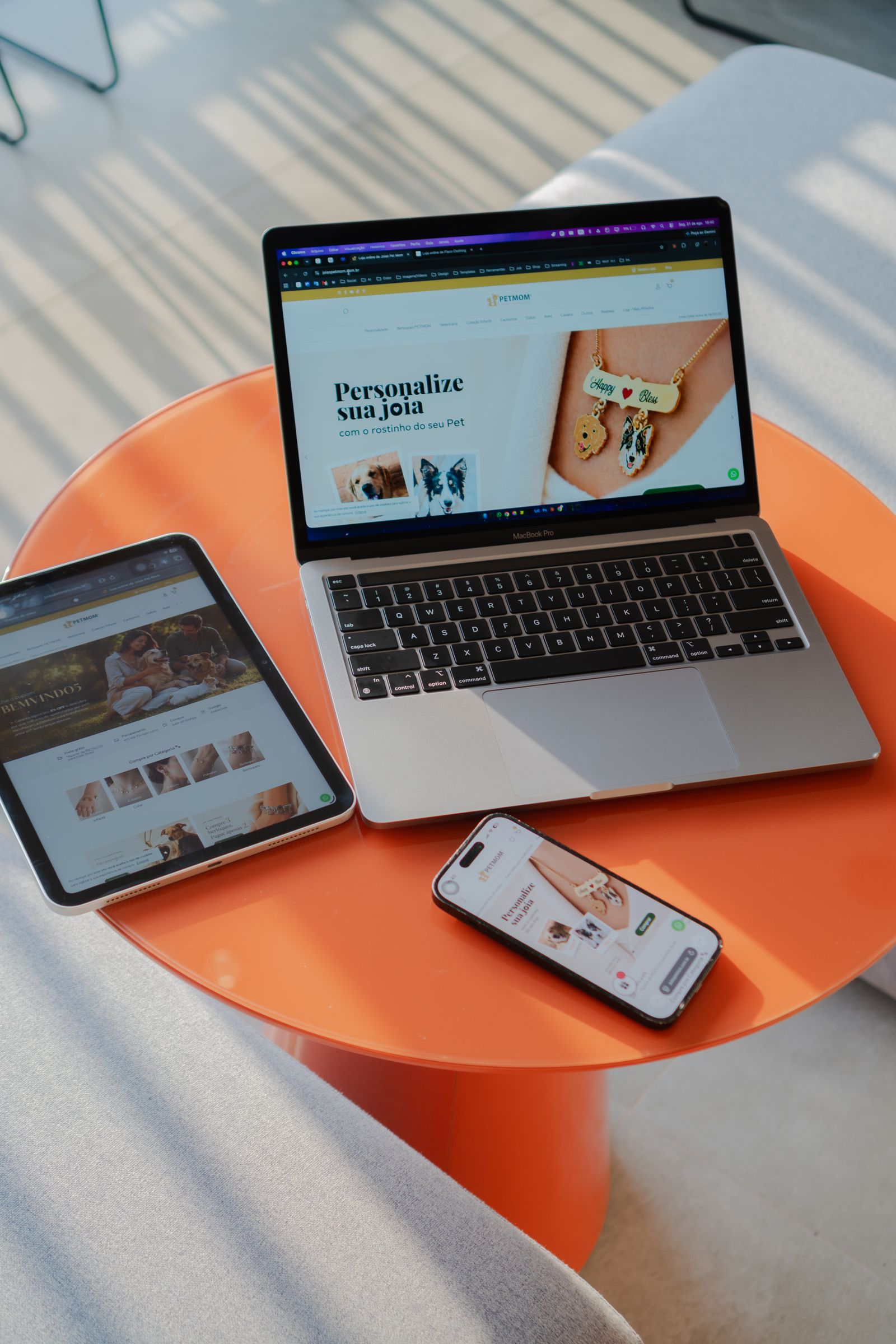 A website shown on a laptop, a tablet and a phone on an orange table
