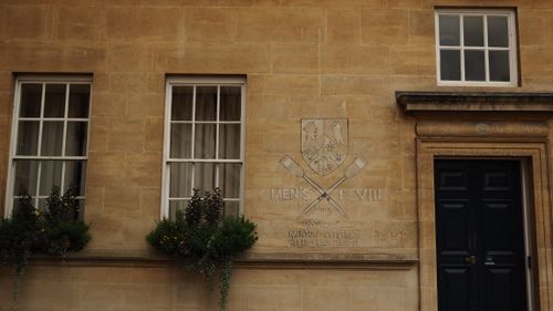 Free Stone building facade with college rowing emblem and window details. Stock Photo