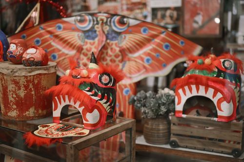 Free Colorful display of traditional Chinese lion dance masks and koinobori, symbolizing cultural festivities. Stock Photo