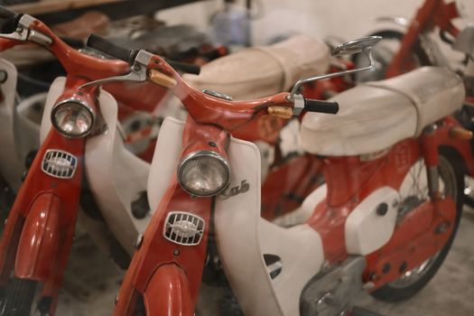 Classic red scooters lined up in a garage, showcasing their nostalgic design and vibrant color.
