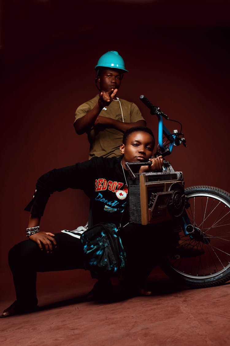 Black Men With Wooden Box And Bicycle On Brown Background