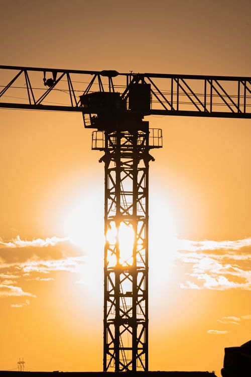 Free A dramatic silhouette of a construction crane against a vibrant sunset in Gölbaşı, Ankara. Stock Photo