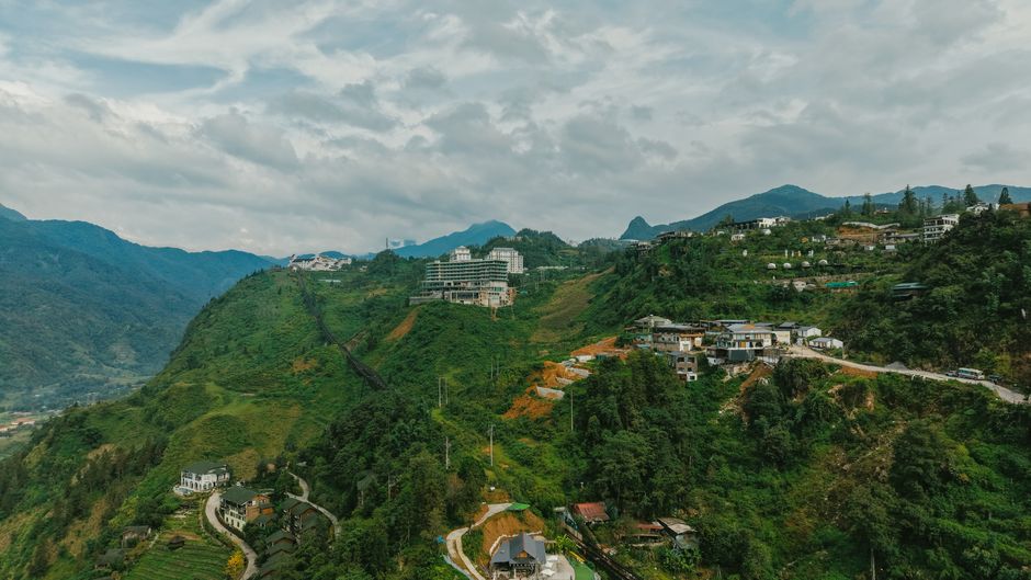 Stunning aerial landscape of green hills and modern buildings in Sapa, Vietnam.