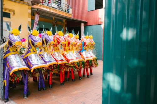 Free Vibrant traditional festival costumes displayed in an outdoor courtyard, showcasing cultural heritage. Stock Photo