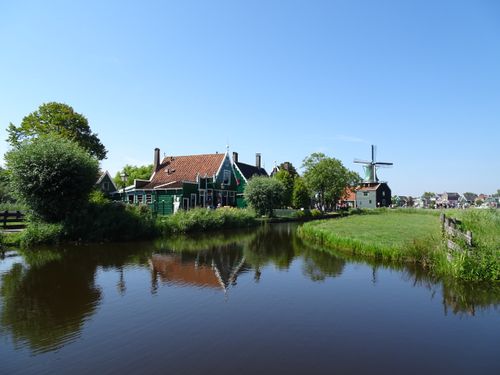 Free Idyllic scene of a traditional Dutch village with windmill and canal in Zaandam. Stock Photo
