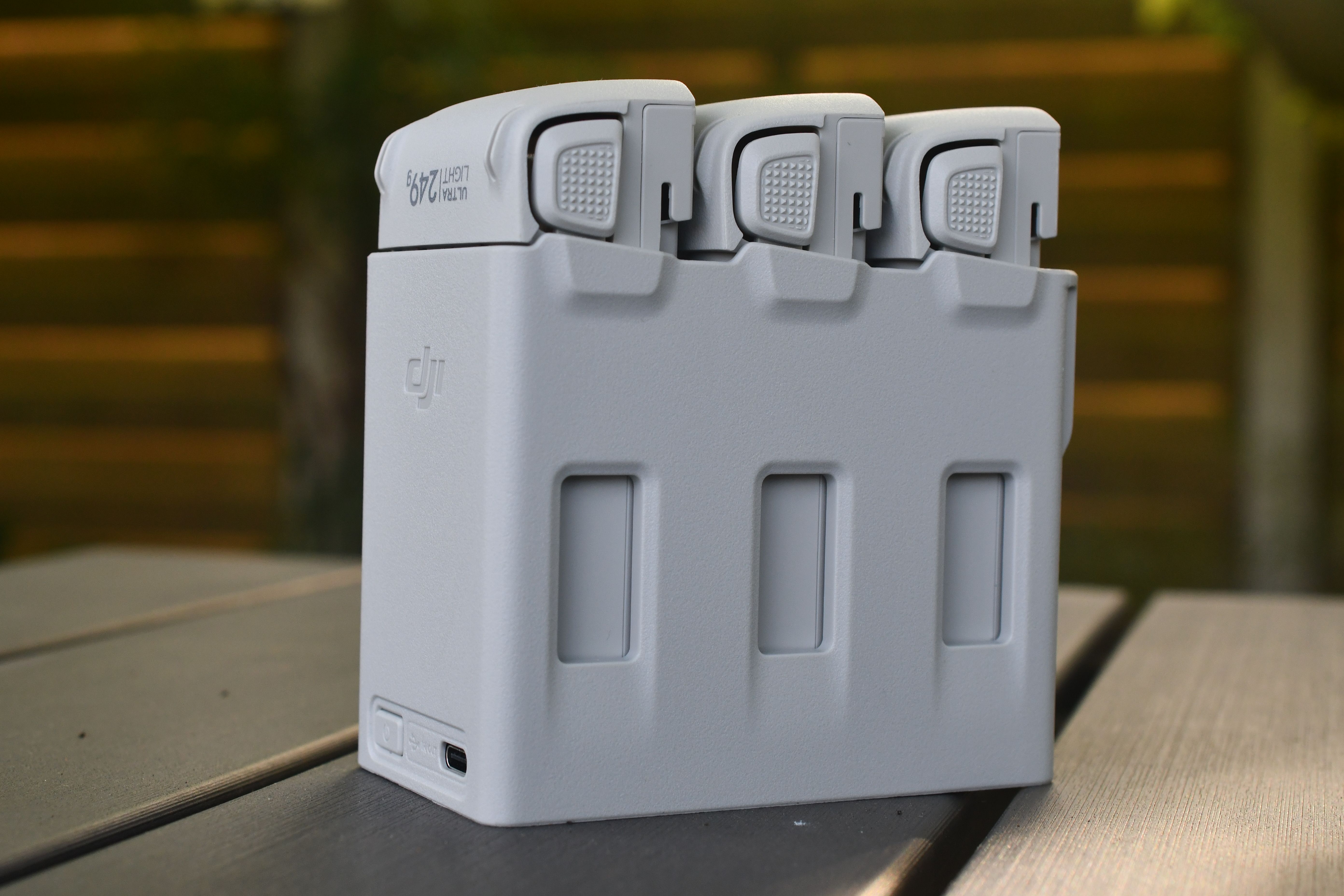 Rectangular battery pack with cables resting on grass outdoors
