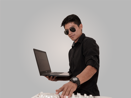 Free A young DJ with a laptop and music mixer, wearing sunglasses and a black shirt. Stock Photo