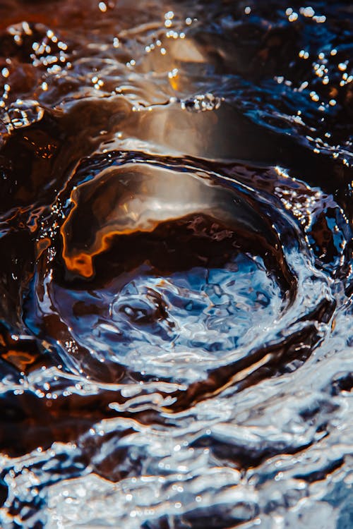 Spectacular view of backdrop representing pure splattering water flow creating waves and swirls while shimmering on dark background