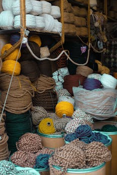 A vibrant assortment of yarns in various colors and textures neatly arranged in a craft store.