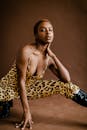 时尚的非裔美国模特穿着豹纹服装摆姿势，表情大胆
