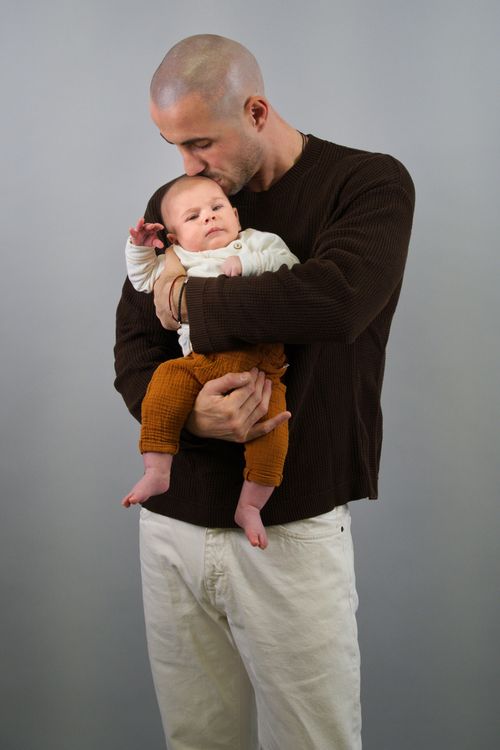 Free A loving father tenderly holds his newborn baby in a studio portrait setting. Stock Photo