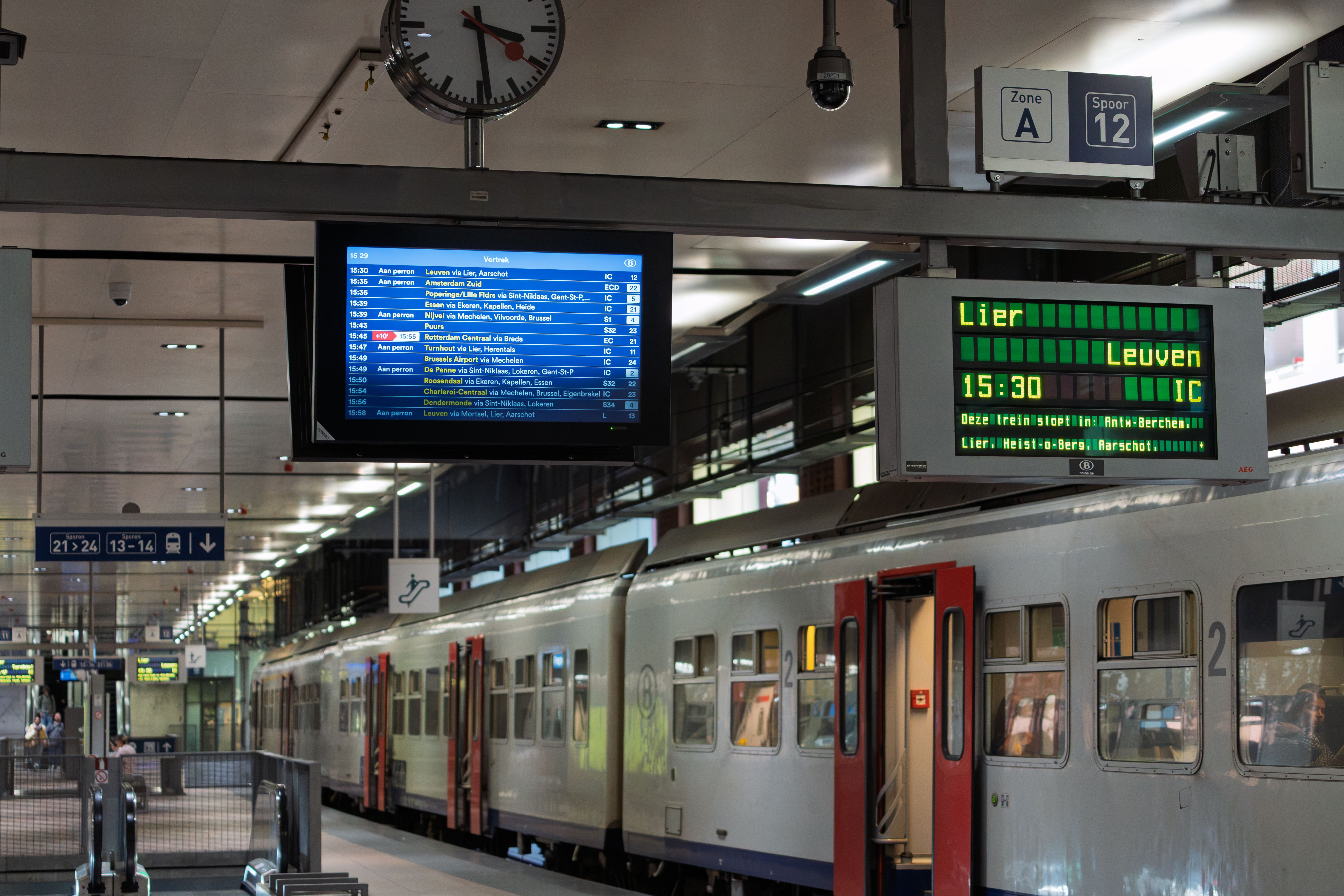 Interieurfoto van een perron op een Europees treinstation met vertrekborden.