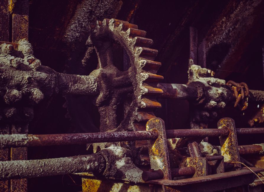 Aged rough metal pipes with corrosion on surface and ribbed valve with dense texture covered with plaque and bright spots