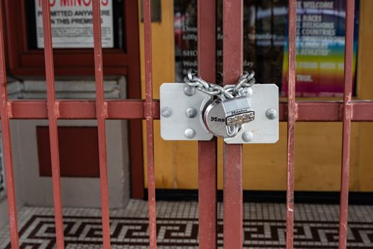 Iron gate with a padlock securing a closed entrance in Portland, Oregon.