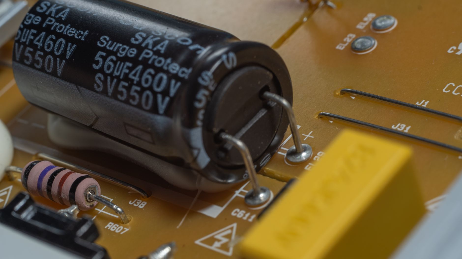Ingeniero eléctrico especializado realizando mediciones técnicas en un gabinete de interruptores de potencia de media tensión dentro de una planta industrial.