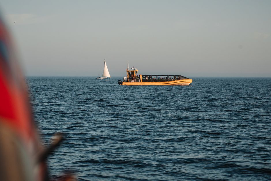 Tour boats navigating the waters of Tadoussac, Québec, Canada during a serene sunset.