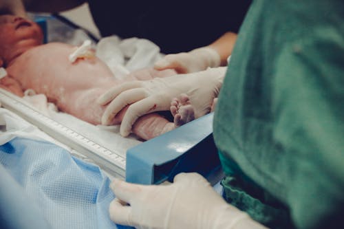Free Person Touching A Newborn Stock Photo