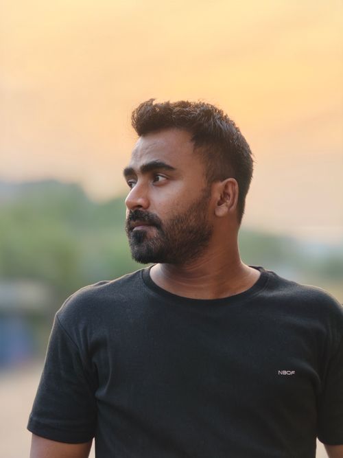Free Portrait of a man looking away with a serene sunset backdrop. Outdoors, casual, thoughtful. Stock Photo