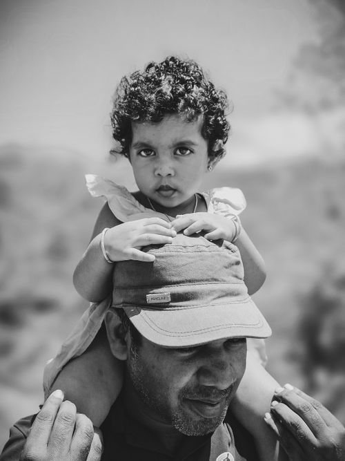 Free Intimate black and white portrait of a father carrying his child on shoulders, showcasing family love. Stock Photo