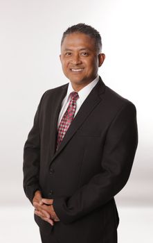 Confident businessman posing in a formal suit against a neutral background. Ideal for corporate use. - Fotografer Sidoarjo