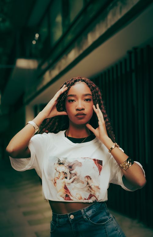 Free Stylish young woman in a modern urban setting, confidently posing in casual streetwear. Stock Photo