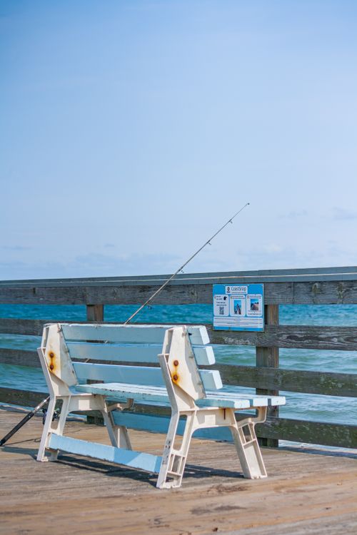 Free Peaceful bench on a sunny day at Virginia Beach pier, perfect for fishing and relaxation. Stock Photo