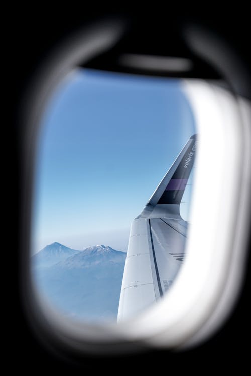 Airplane Window View of Snow Covered Mountains