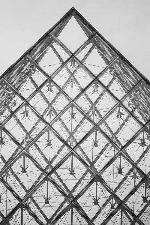 Free Monochrome image capturing the geometric elegance of the Louvre Pyramid in Paris, France. Stock Photo