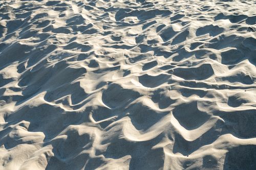 Free Textured sunlit sand dunes creating abstract patterns in Occitanie, France. Ideal for nature and travel themes. Stock Photo