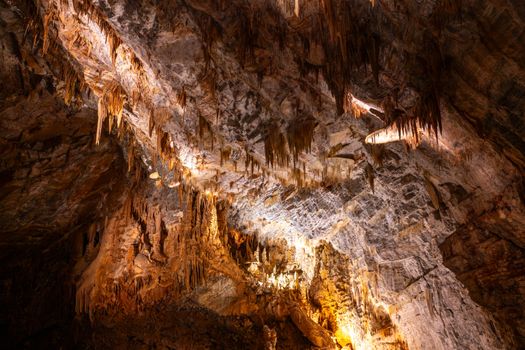 Explore the stunning stalactite formations illuminated inside Cabrespine Cave, Occitanie, France.