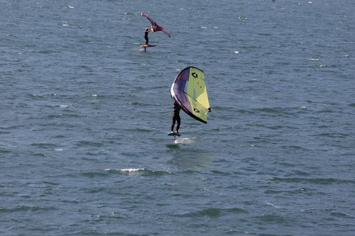 Free Two people enjoying wing foiling on Lake Garda, Italy, a popular water sport destination. Stock Photo