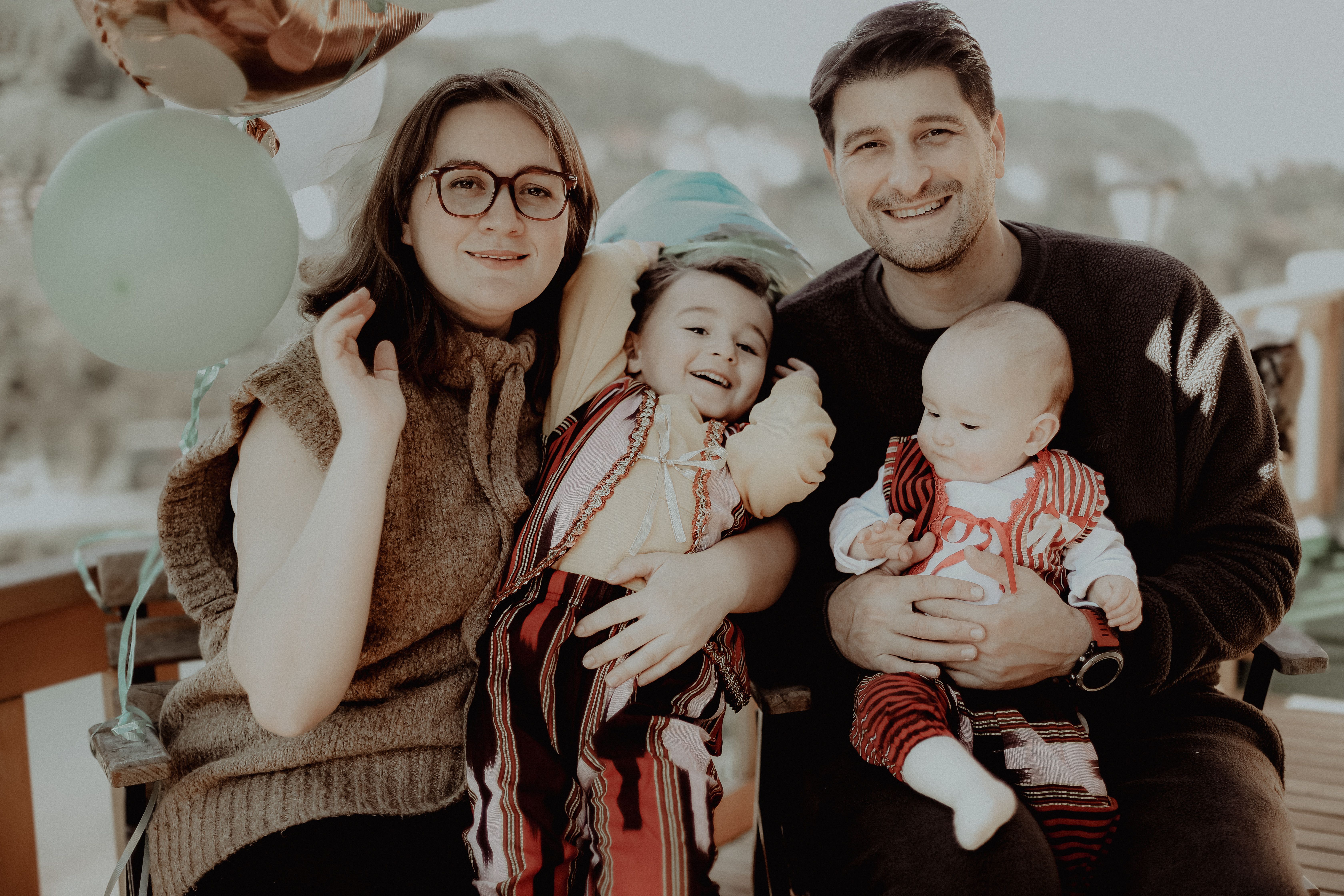 A joyful family of four enjoying time together outdoors, capturing a moment of happiness and celebration. - Photo by Ahmet Mert on Pexels