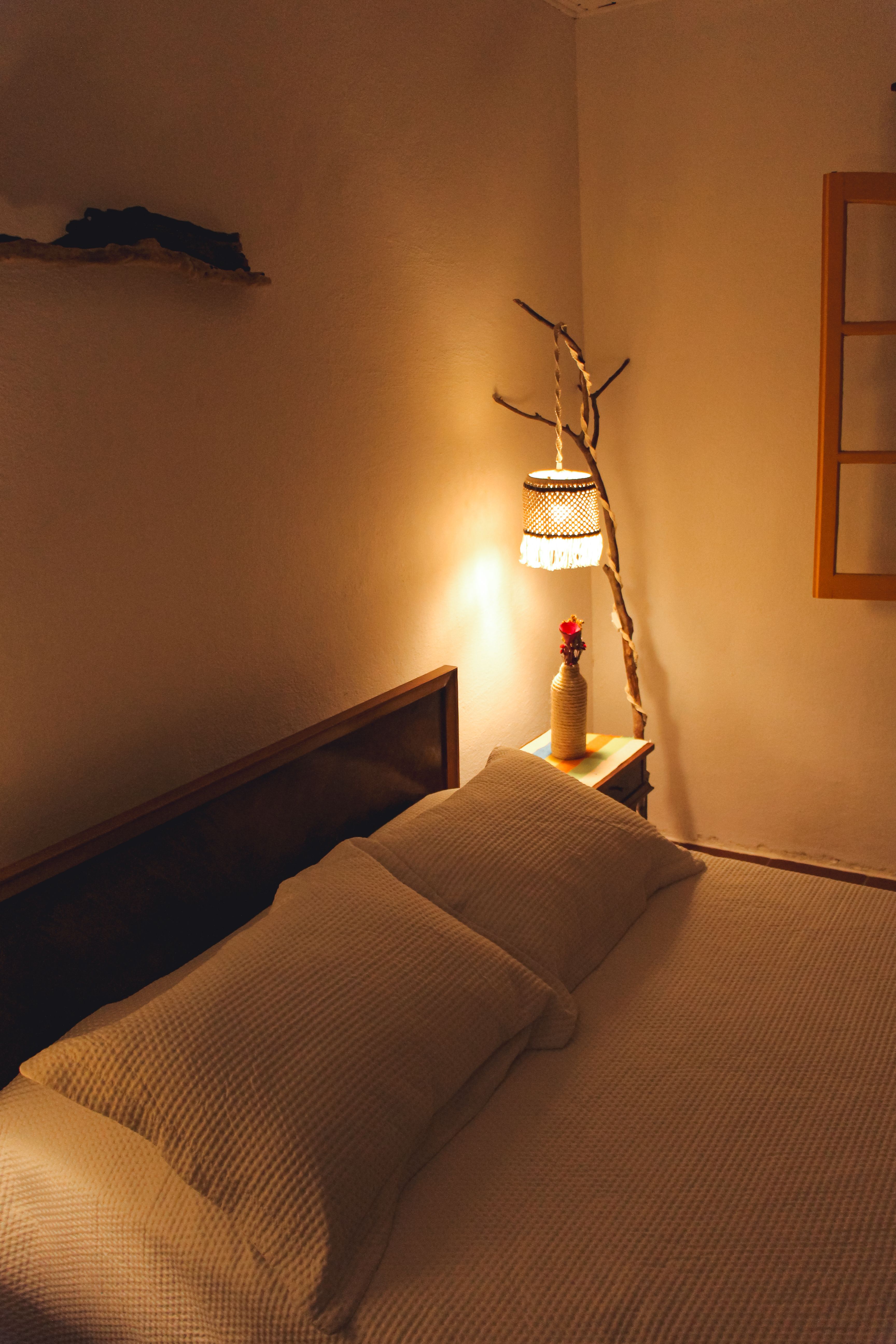 Fotomural Un dormitorio cálido y acogedor con iluminación ambiental y decoración rústica, perfecto para una escapada confortable.