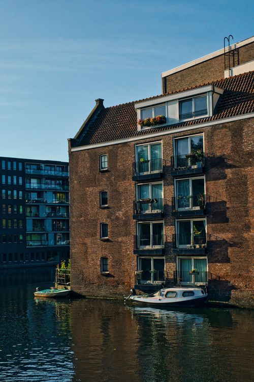 Free Scenic view of traditional canal houses and boats in Amsterdam, Netherlands. Stock Photo