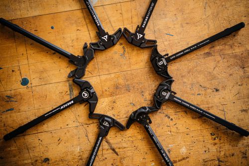 Free A flat lay of AR-15 charging handles arranged in a circle on a workshop table. Stock Photo