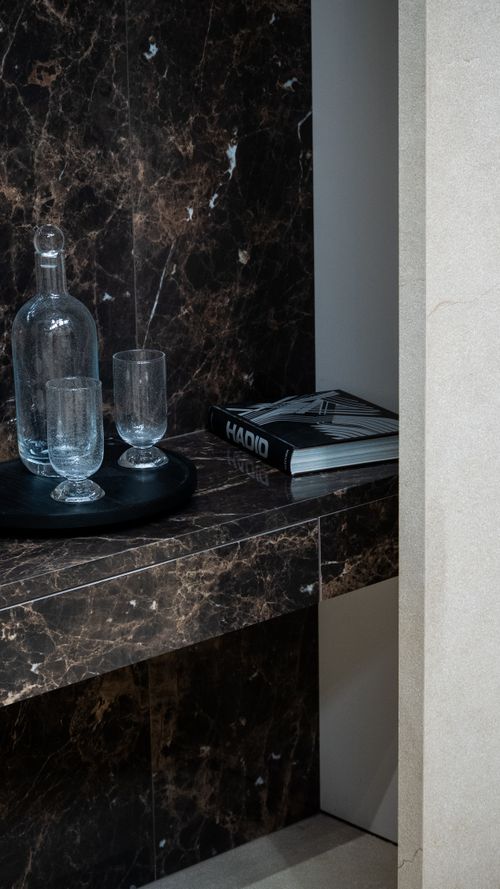 Free Stylish marble shelf featuring clear glassware and a decorative book, ideal for modern interiors. Stock Photo