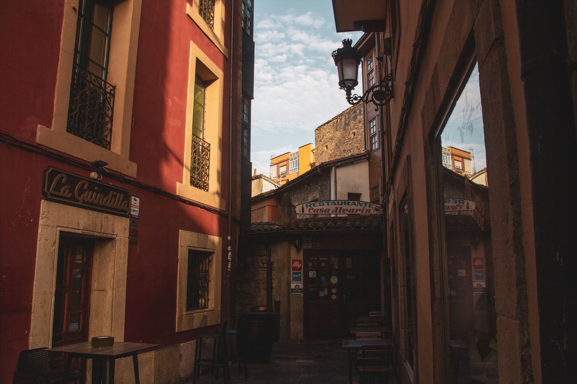 Rustic street with cozy restaurants in Avilés, Spain, capturing a quaint European charm.