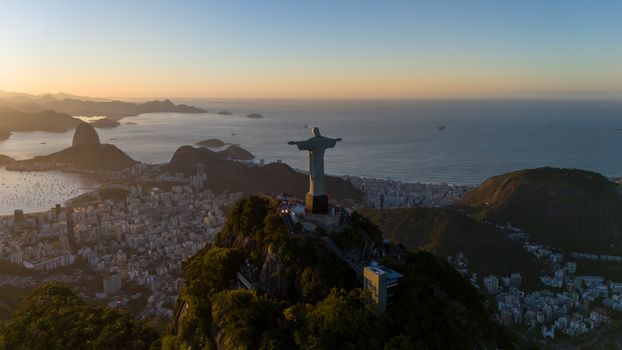 Stunning aerial view of Christ the Redeemer overlooking Rio de Janeiro at sunrise.