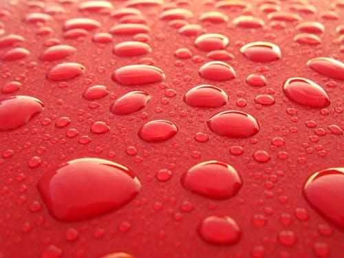 Free Water Droplets on Red Surface Stock Photo