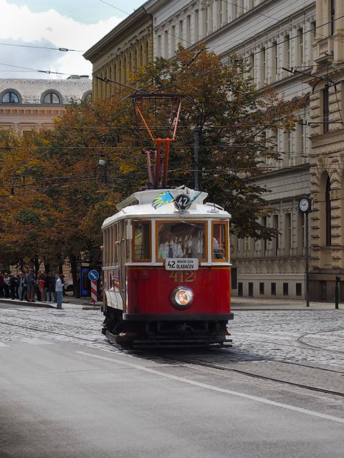 Free Vintage red tram navigating through the cobblestone streets of Prague on a sunny day. Stock Photo